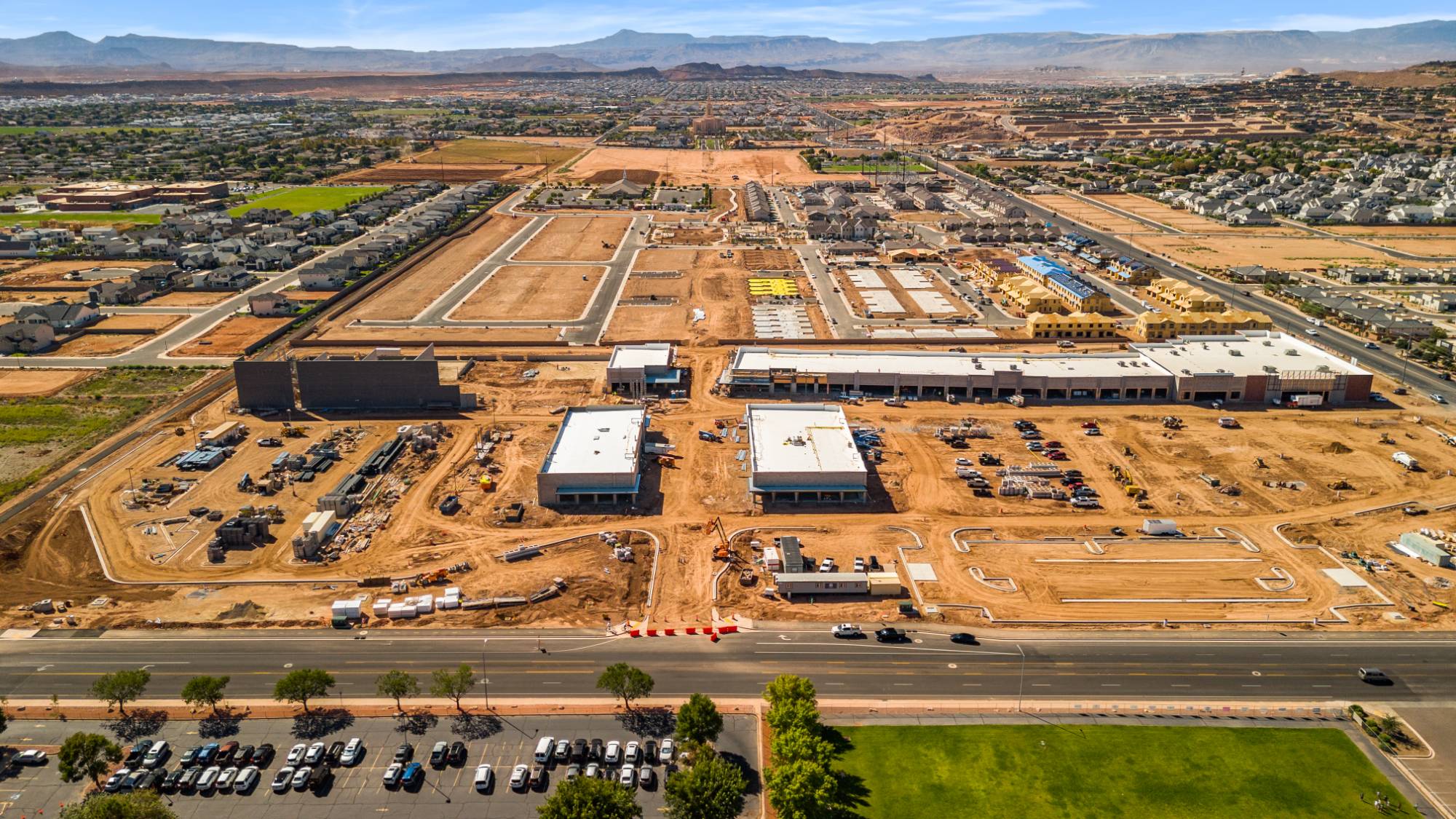 Wide aerial of The Paseo under construction, with the St. George temple on the horizon