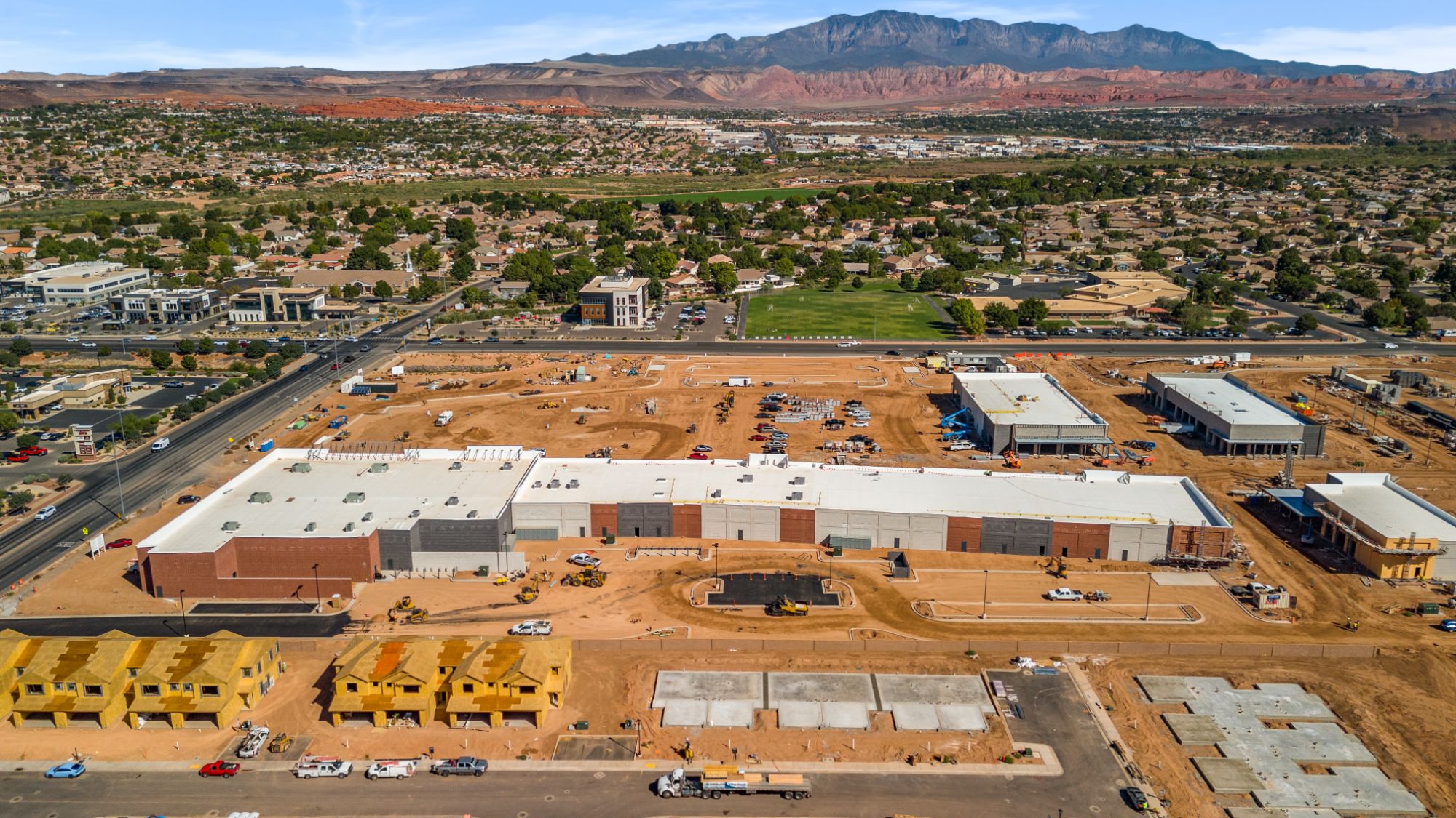 Aerial view of The Paseo under construction in St. George, with the retail shells framed against Pine Valley Mountain